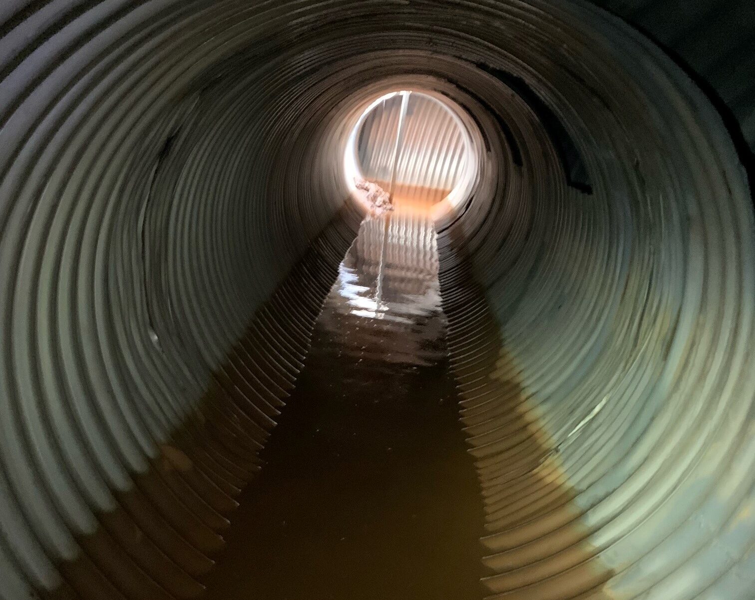 The inside of a large pipe underneath a detention pond.
